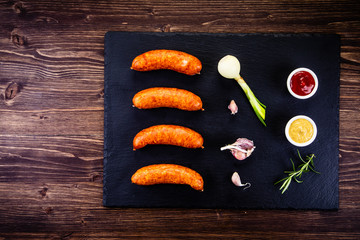 Raw sausages and ingredients on cutting board