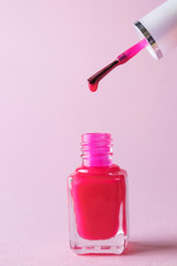 Red nail polish in a bottle on a light background. Svehru brush with flowing paint. The concept of beauty, manicure, for women. Minimalism, place for text.