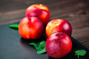 Plums on black stone plate