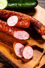 Raw sausages and vegetables on cutting board