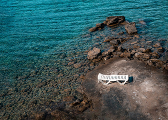 Sunbed on stones beach. Seascape summer background