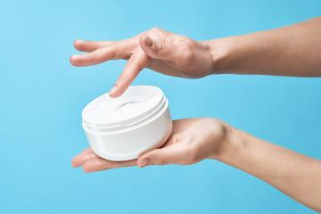 woman applying cream on her face