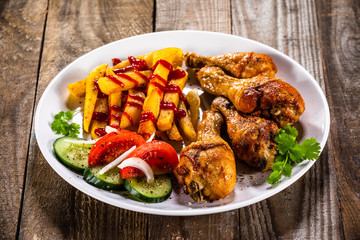 Grilled chicken drumsticks with french fries and vegetables