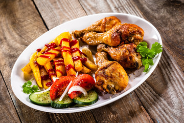Grilled chicken drumsticks with french fries and vegetables