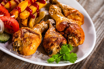 Grilled chicken drumsticks with french fries and vegetables