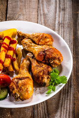 Grilled chicken drumsticks with french fries and vegetables