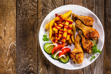 Grilled chicken drumsticks with french fries and vegetables