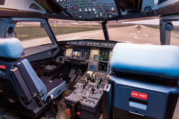 Cockpit of airliner simulator. Switches and dials visible in the background.