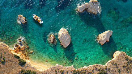 Aerial drone photo of traditonal fishing boat docked in small islet of Glaronisi with paradise emerald rocky beaches, Koufonisi island, Small Cyclades, Greece