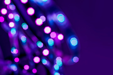 Colorful lights blurred background. Abstract illuminated texture. Christmas, new year or birthday celebration. Night life photography. Blue and purple neon colors overlay. Space for text