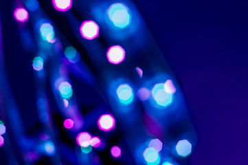 Colorful lights blurred background. Abstract illuminated texture. Christmas, new year or birthday celebration. Night life photography. Blue and purple neon colors overlay. Space for text