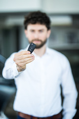 Obraz na płótnie Canvas Car handsome salesman giving Key of New Car at Showroom