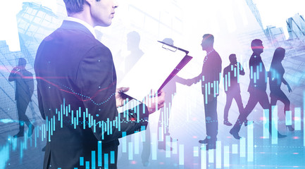 Man with clipboard and his team in city, graphs