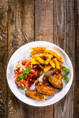 Grilled chicken wings, chips and vegetables