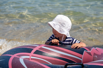 Boy playing and an inflatable rubber ring on beach