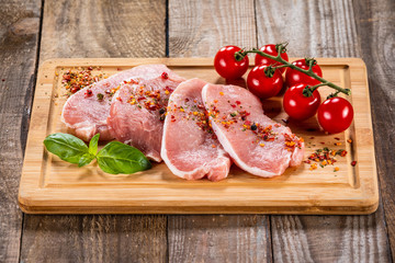 Raw pork chops on cutting board