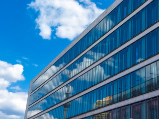 Cloudy sky reflected in the glass wall of a high building