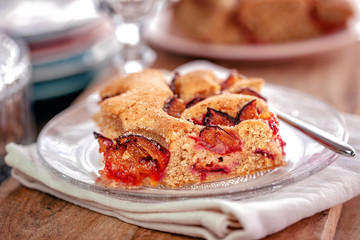 Ein frisches geschnittenens Stück Pflaumenkuchen auf dem Teller