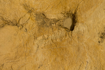 Rugged yellow rock texture with a hole