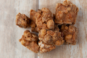 Sweet kid's foot, seen from above .Focused close-up.Traditional in june, julina, augustine feasts.Redneck party.Peanut and rapadura.Pale wood color background. Seen up close.
