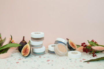 jar of luxury eyeshadow on terrazzo dish, pink background, flower decoration, copy space