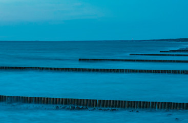 Coastline with breakwaters after sunset