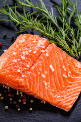 Fresh raw salmon fish served on black stone