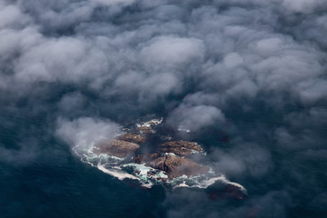 Aerial View from Above of the Rocky Islands covered in Clouds and Fog near the West Pacific Ocean Coast. Taken near Tofino and Ucluelet in Vancouver Island, BC, Canada.