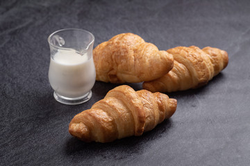 Fresh croissants on black slate background. Copy space