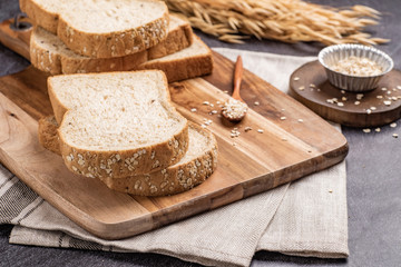 Sliced bread with sunflower seeds oat and sesame on a wooden plate.