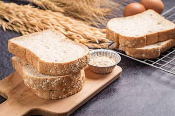 Sliced bread with sunflower seeds oat and sesame on a wooden plate.