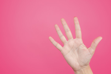 Closeup view of beautiful manicure female hand isolated on pink background. White caucasian woman showing her five fingers. Horizontal color photography.