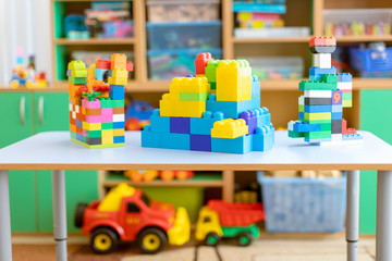 toy cars on the table.Children's playroom with plastic colorful educational blocks toys. Games floor for preschoolers kindergarten. interior children's room. Free space. 