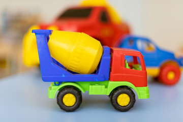 Fototapeta premium toy cars on the table.Children's playroom with plastic colorful educational blocks toys. Games floor for preschoolers kindergarten. interior children's room. Free space. 