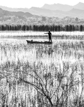 Fishermen in a boat with his net ready to catch a fish at kalar kahar lake in Punjab , Pakistan.