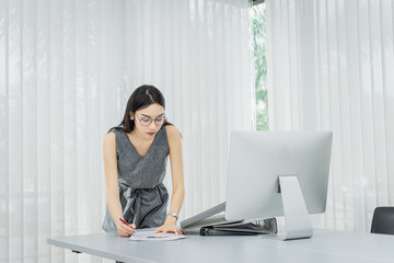 Portrait of beautiful young businesswoman working  in the office.,standing on workplace.