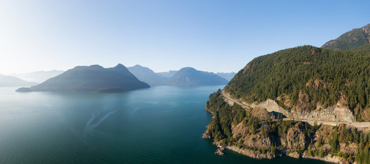 Aerial panoramic view of the Sea to Sky Highway in Howe Sound, North of Vancouver, British Columbia, Canada. Taken during a sunny summer day.