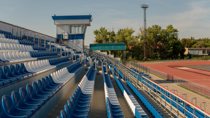 Obraz premium Bleachers in a sports stadium. Red and white seats in a large street stadium.