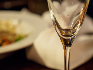 Close-up macro detail of the stem of an empty glass of Champagne served at a French bistro. Shallow focus. London, United Kingdom. Drinks and cuisine.