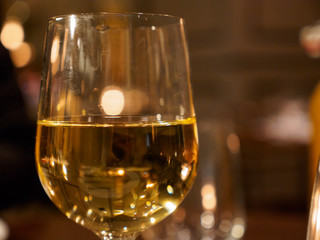Close-up macro detail of a glass of fine white wine served as an aperitif at a French bistro. Shallow focus. London, United Kingdom. Travel and international cuisine.