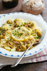 Sicilian tagliatelle pasta with lemon, garlic and olives, garnished with sunflower seeds.
