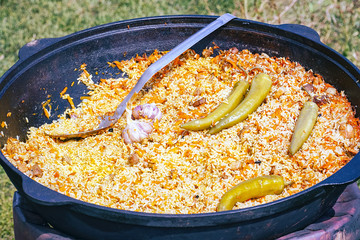 Traditional delicious pilaf with vegetables in a cauldron