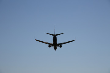 Fototapeta na wymiar Airplane in a blue clear sky. The plane takes off or lands for landing. Air passenger transport.