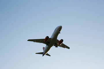 dark silhouette of airplane flying on the blue sky. With copy space for text or image. Close-up. Air passenger transport.