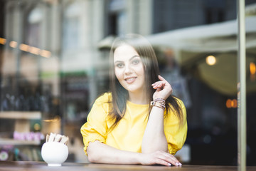 portrait of a beautiful girl in a cafe overlooking the street