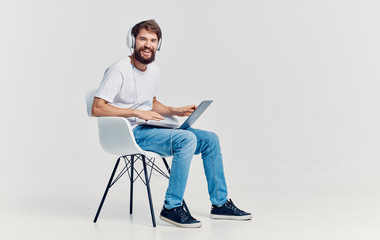 young man sitting on a chair and working on his laptop