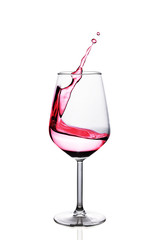 Red wine splash in glass isolated over white