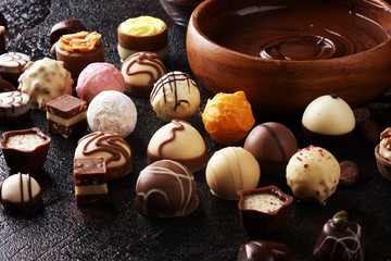 a lot of variety chocolate pralines, belgian confectionery gourmet chocolate on rustic dark background