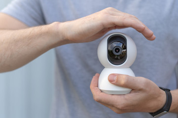 Protection video CCTV security camera with handyman hand roof. Home guard safety life concept.