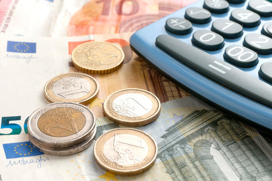 Some euro coins on euro banknotes and a calculator